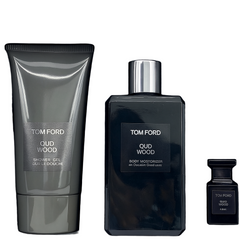 Tom Ford Oud Wood fragrance set with bottle, tube, and small container on a black background
