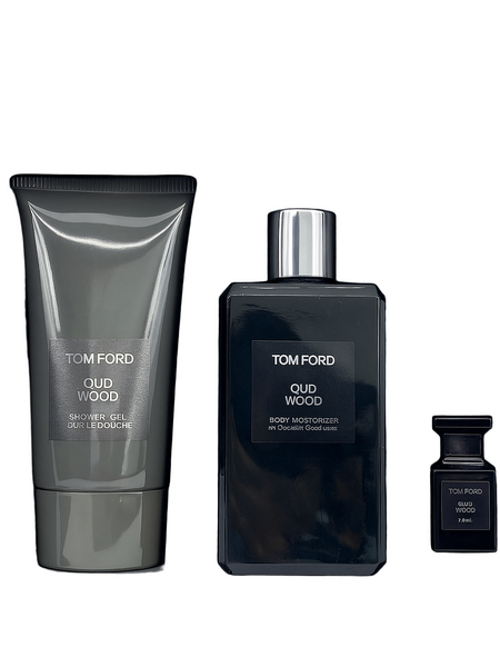 Tom Ford Oud Wood fragrance set with bottle, tube, and small container on a black background