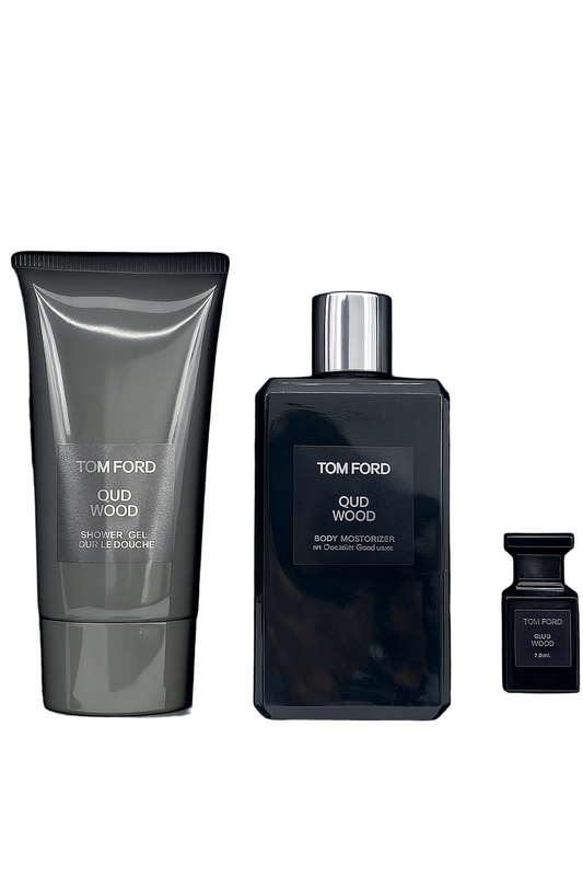 Tom Ford Oud Wood fragrance set with bottle, tube, and small container on a black background