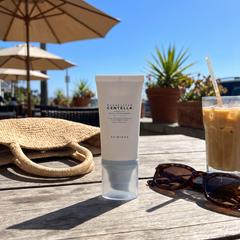 SKIN1004 Centella Hyalu-Cica Sun Serum SPF50+ on a sunny outdoor cafe table